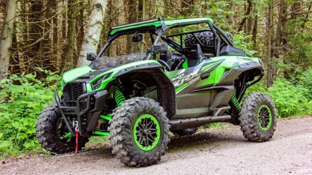 Green Kawasaki KRX on rocky trail with cargo bed